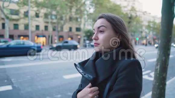 一个女孩在等公共汽车或出租车背景城市交通视频的预览图