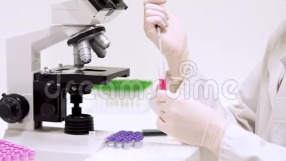 在实验室进行医学测试科学家在实验室使用微型吸管把液体注入管子里视频的预览图