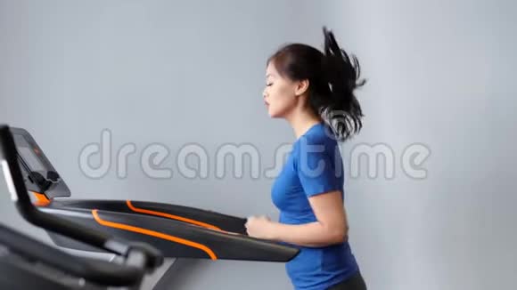 慢动作健身亚洲妇女在健身房或家庭中弹跑步机上做有氧运动视频的预览图