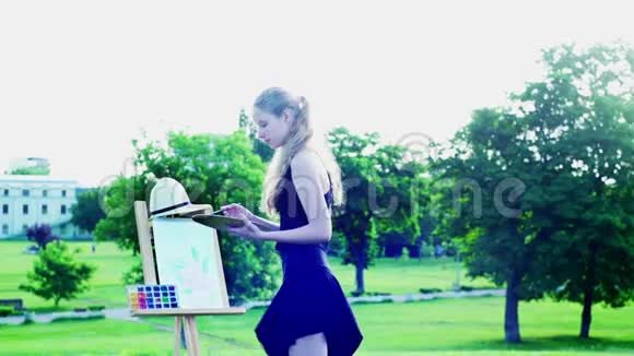 女孩在公园里画着绿色的草和树视频的预览图