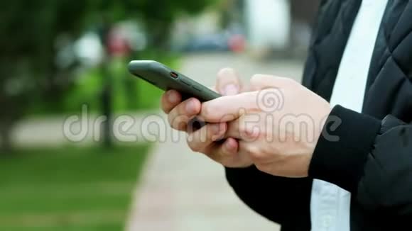 男人手里拿着现代手机男人在打短信聊天视频的预览图
