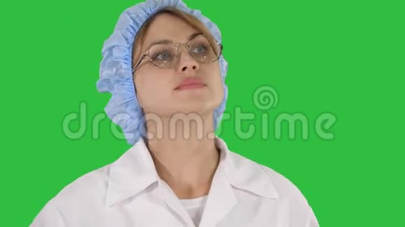 戴眼镜戴帽子的女医生在绿色屏幕上走来走去用彩色键视频的预览图