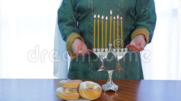 犹太妇女在光明节上用漂亮的烛台点燃蜡烛视频的预览图