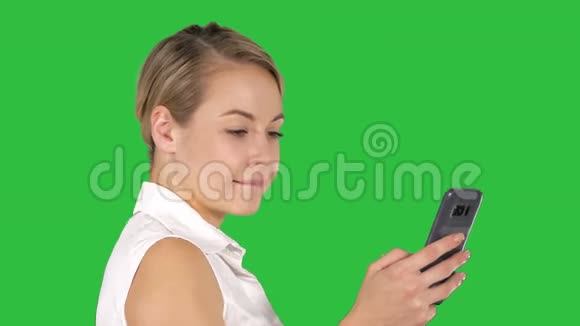 年轻漂亮的女人在绿色屏幕上写短信Chroma键视频的预览图