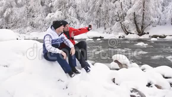 两个人在一条山河的岸边在树林里的博客上打电话玩得很开心视频的预览图