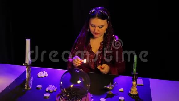 在神奇的沙龙里吉普赛人点着蜡烛表演魔术视频的预览图