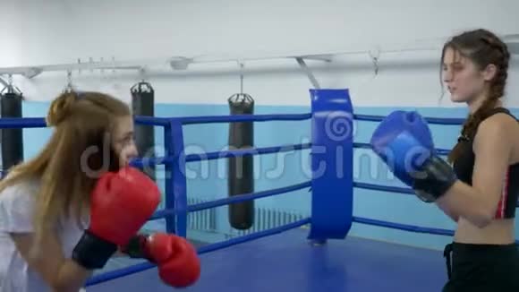 体育与人年轻女子在体育馆拳击场上的锻炼与格斗视频的预览图