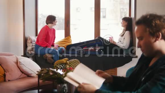 一个男性正在读一本书一个女人在后台聊天视频的预览图