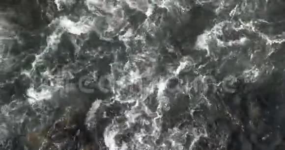 山河青绿色的水剧烈流动撞击黑色岩石沸腾并产生大量白色泡沫空中飞行视频的预览图