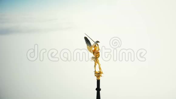 超级特写航拍金色圣迈克尔雕像在圣米歇尔山城堡堡垒尖顶上方多云的天空视频的预览图