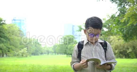 小男孩在上学的路上读这本书视频的预览图