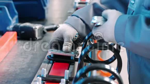 工厂工人把金属垫放在螺栓上工厂装配车间手工作业视频的预览图