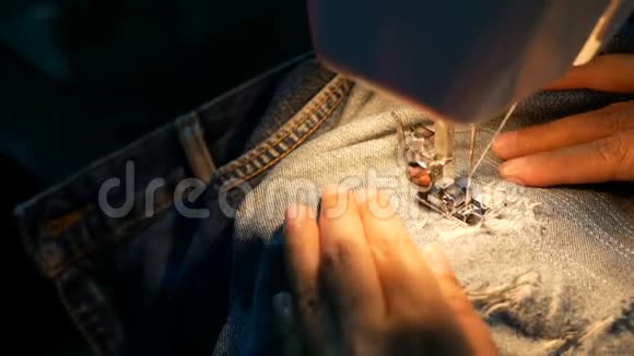 4K镜头一个女人用缝纫机缝补蓝色牛仔牛仔裤视频的预览图
