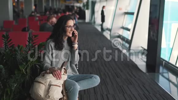 在机场休息室用手机说话的女孩视频的预览图