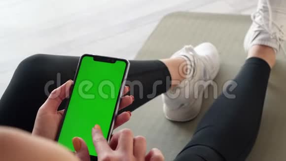 绿色屏幕智能手机手中的运动女性特写视频的预览图