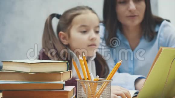 母亲在做家庭作业时坐在家里的桌子旁学习困难对女儿感到沮丧视频的预览图
