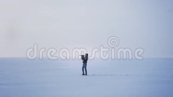 白种人音乐家在冰冻的湖泊背景下积极地吹喇叭视频的预览图