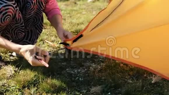 快乐旅游女孩在山上搭帐篷放松拉帐篷钉在露营视频的预览图