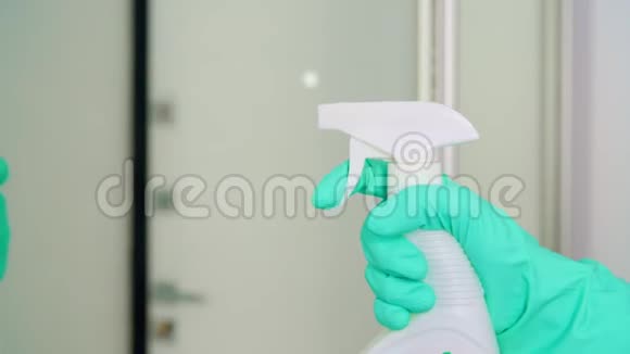 戴手套的女人在家用抹布和清洁剂喷洒清洁镜视频的预览图