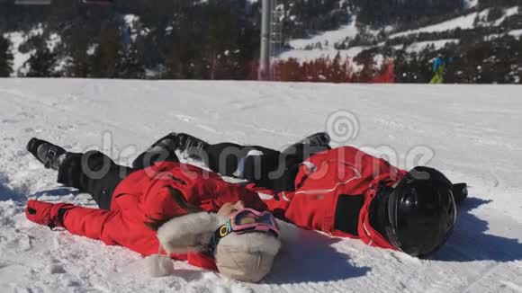 快乐的一对滑雪者躺在雪地里年轻人在山区度过许多有趣的寒假视频的预览图
