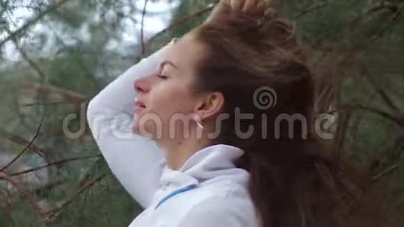特写站在风中的女人画像微风在玩女孩的头发暴风雨天气秋季冬季视频的预览图