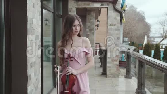 优雅的小提琴手在家里散步和拉小提琴视频的预览图