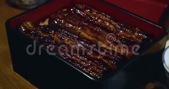 乌纳吉烤鳗鱼在漆盒里的米饭上供应唐伯里风格视频的预览图