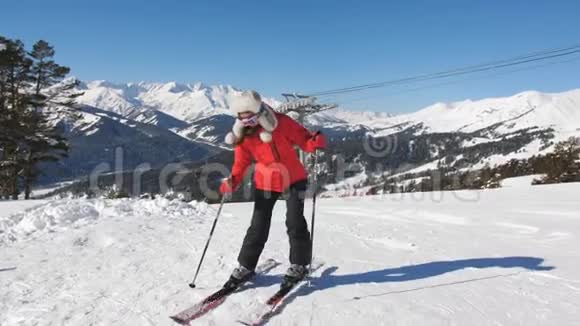 一个女人害怕一个陡峭的斜坡在滑雪场的侧面站起来靠在滑雪边缘视频的预览图