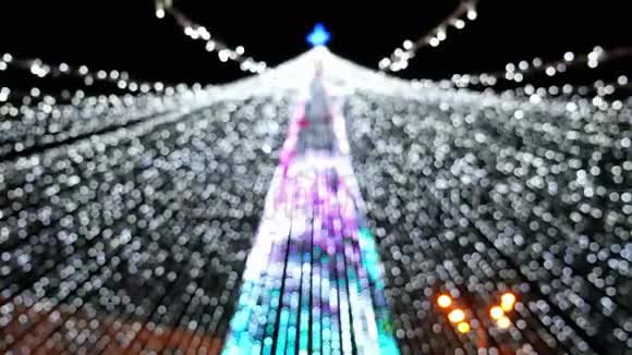 城市圣诞树上花环灯光模糊的背景视频的预览图