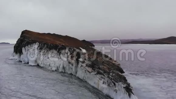 冰盖在冰冻的湖面上的岩石视频的预览图