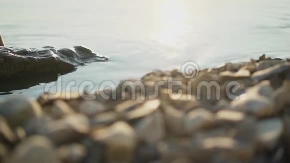 跟随一只赤脚的女性脚行走溅在海水的波浪上电影稳定镜头视频的预览图