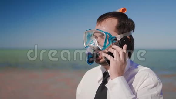 海滩上的商人戴着潜水面罩和浮潜在通话视频的预览图