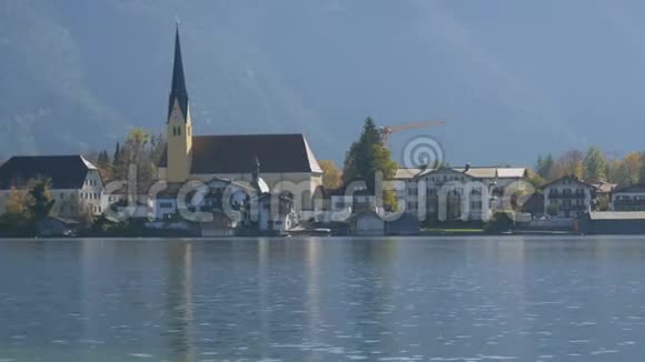 美丽的老教堂坐落在泰格恩湖畔巴伐利亚阿尔卑斯山的背景上充满活力视频的预览图