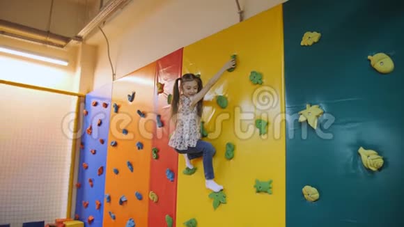 在蹦床娱乐中心小女孩带着五颜六色的柔软立方体跳进游泳池视频的预览图