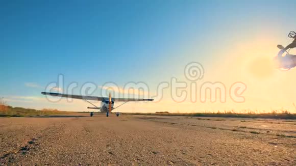 阳光跑道男飞行员朝飞机走来检查螺旋桨视频的预览图