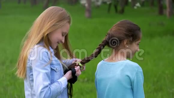 漂亮的小女孩编辫子的小女朋友在头上扎辫子视频的预览图