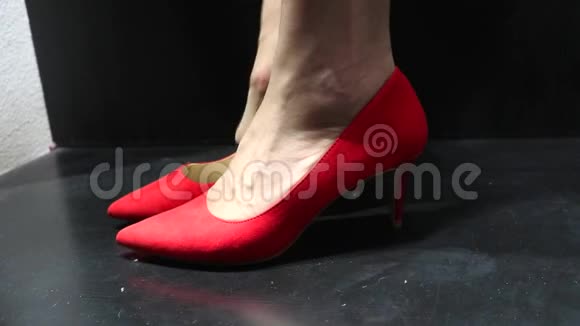 女人在店里试穿漂亮的红色绒面鞋跟视频的预览图