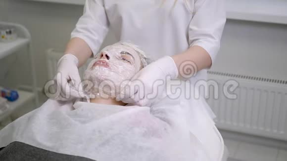 医生美容师从女孩身上取下一张透明的胶卷视频的预览图