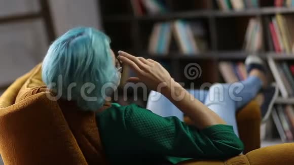 在舒适的椅子上放松的时髦女人视频的预览图