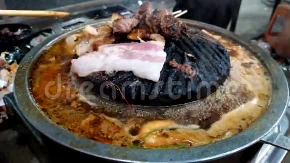 烤猪肉放在锅子上锅子是从热中燃烧出来的虾子放在沸腾的汤里有很多烟视频的预览图