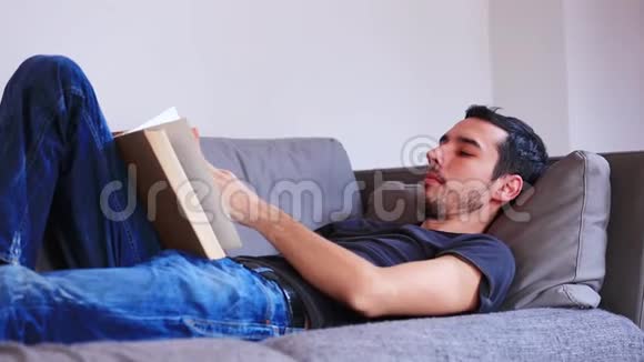 年轻人躺在沙发上看书视频的预览图
