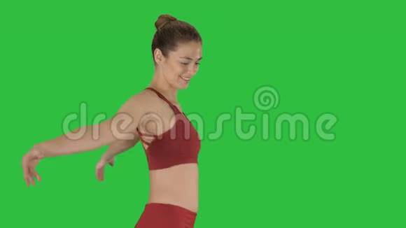 性感的健身女运动员伸展手臂在绿色屏幕上笑Chroma键视频的预览图