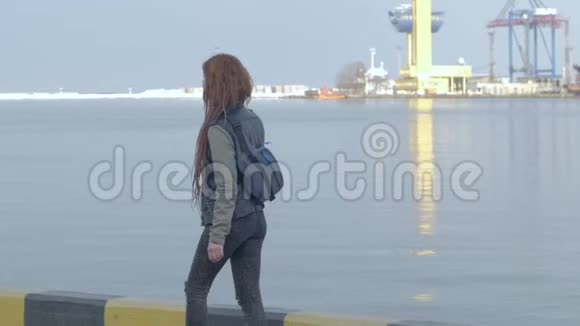 女性旅行者走在海港附近视频的预览图