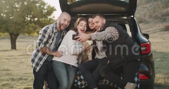 一群朋友在一次旅行中与一只哈士奇狗在汽车后备箱里自拍在大自然中视频的预览图