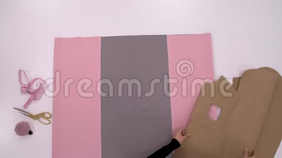 设计师的手在为制作运动衫准备粉色和灰色的布料视频的预览图
