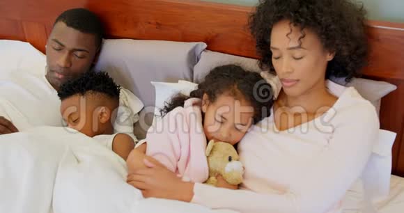 在家睡在卧室的黑人家庭的正面景色视频的预览图