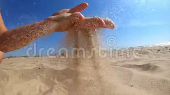 慢动作女孩拿起一把沙子在她的手掌和洒视频的预览图