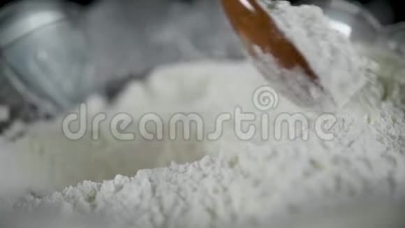 混合面粉和面团用木勺在黑暗的背景上烤蛋糕视频的预览图