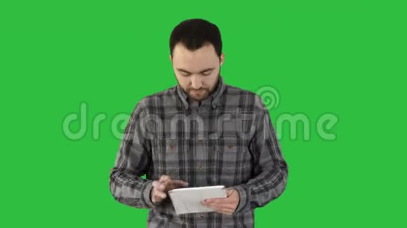 年轻的商人用他的标签走在绿色屏幕上Chroma键视频的预览图
