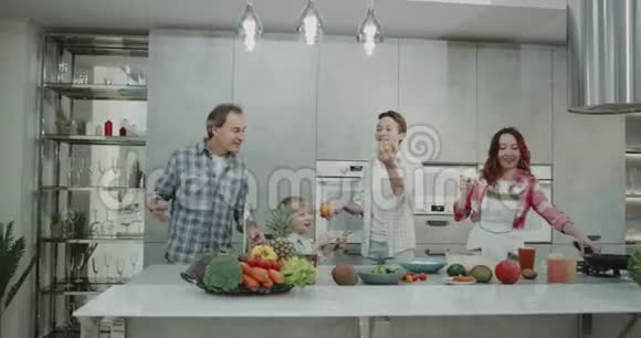 成熟的父母和他们的两个孩子一起在厨房里度过一个家庭的一天同时在16年的时间里做菜视频的预览图